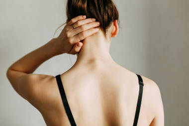  頸部和背部受傷，工作倦怠。受傷的區(qū)域,畫面在空白的背景上.女孩脖子上的痙攣