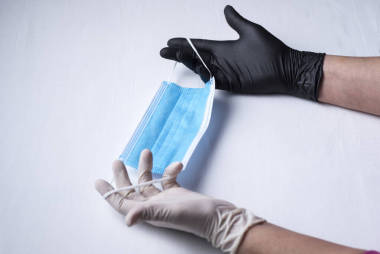 衛(wèi)生面具，一張藍(lán)色臉，另一張白色，有兩條彈性帶，雙手拿著衛(wèi)生手套，一只白色，另一只黑色，背景為白色