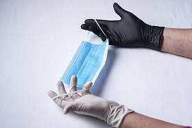 卫生面具，一张蓝色脸，另一张白色，有两条弹性带，双手拿着卫生手套，一只白色，另一只黑色，背景为白色