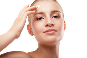 女人在孤立的脸上应用保湿霜