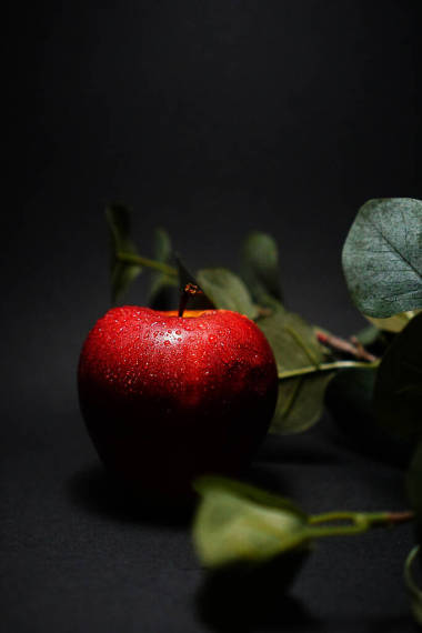 紅蘋果，底色為黑色，有水滴圖片