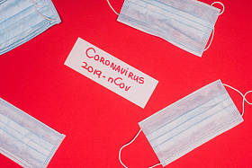 带有coronavirus 2019-nCov字体的红底医学口罩卡片的顶部视图