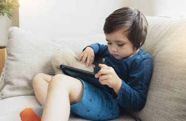 坎德拍攝可愛的小男孩在平板電腦上看卡通片，孩子在網(wǎng)上使用數(shù)字平板搜索信息做作