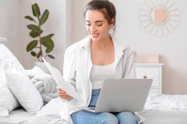 在家里用筆記本電腦工作的年輕漂亮的女人