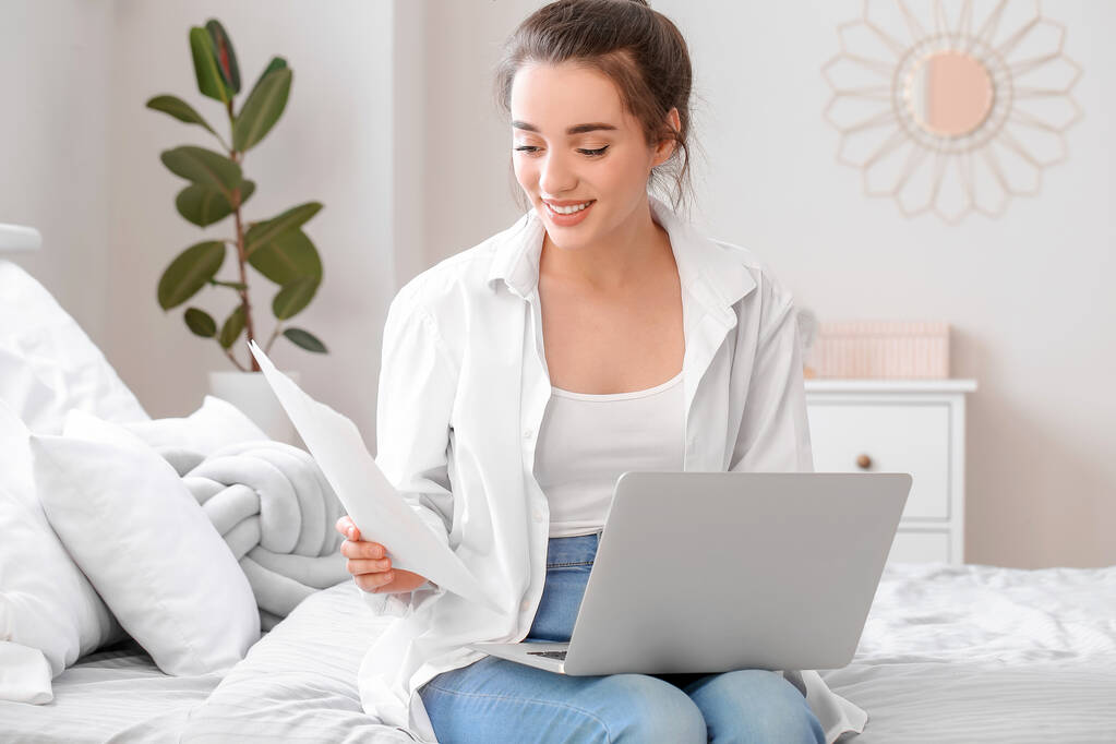 在家里用笔记本电脑工作的年轻漂亮的女人 在家里用笔记本电脑工作的年轻漂亮的女人