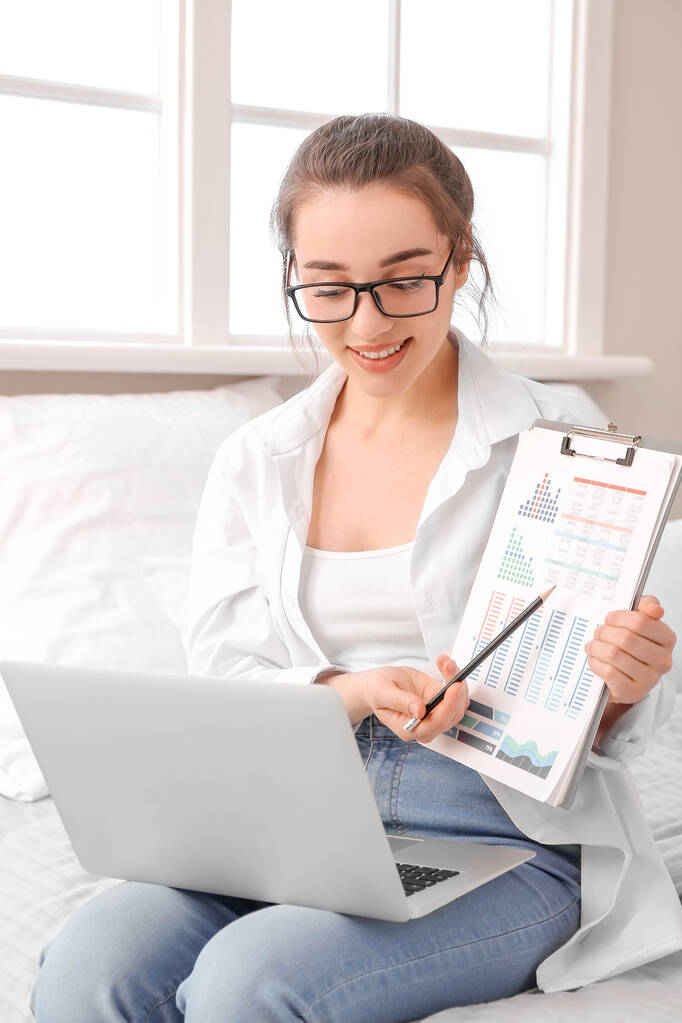 在家里用笔记本电脑工作的年轻漂亮的女人 在家里用笔记本电脑工作的年轻漂亮的女人