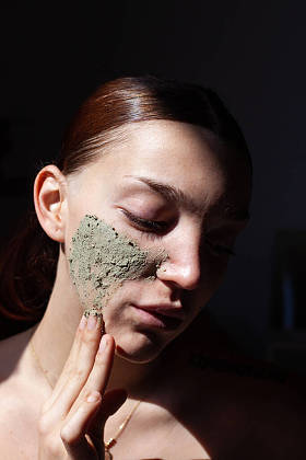 美容美发女子在脸上涂些护肤霜的肖像