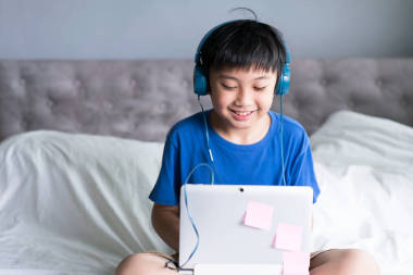 小男孩在網(wǎng)上游戲或教育中使用筆記本電腦