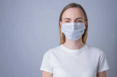 戴著醫(yī)療面罩的婦女，在灰色背景下被隔離