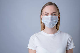 戴着医疗面罩的妇女，在灰色背景下被隔离