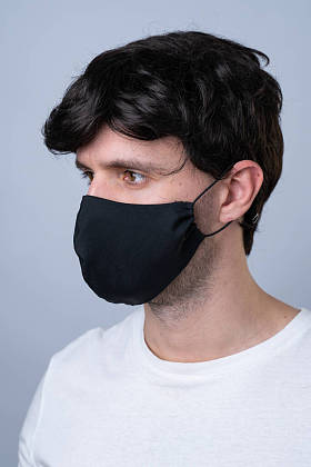 戴着黑色医疗面具的男人,在灰色背景下被隔离