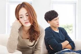 坐在沙发上在冲突期间对年轻夫妇
