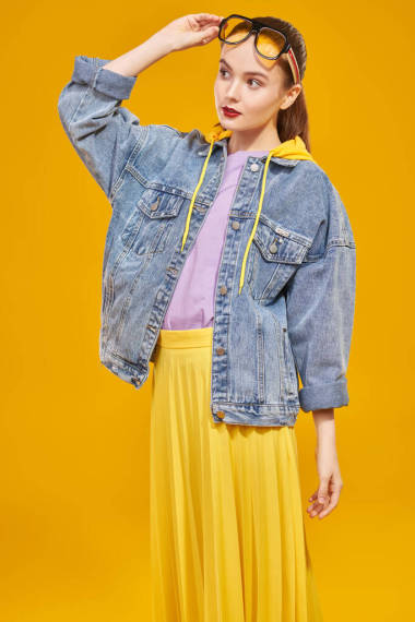 现代年轻人的样子。穿着鲜艳夏装的年轻漂亮的姑娘穿着现代太阳镜,背景是黄色的.漂亮，时