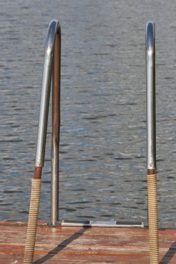 舊金屬梯子在湖游泳