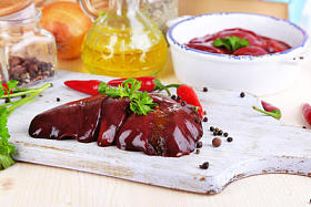 生的肝脏在潘和木板与香辛料和调味品在木桌特写