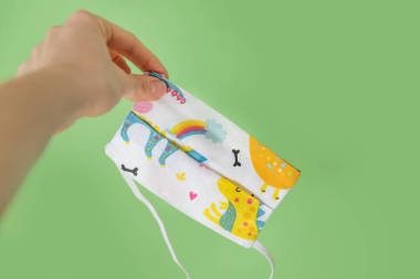 淺綠色背景的Covid-19珊瑚大流行病期間恐龍的兒童保護(hù)膜