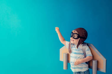 快樂的孩子在藍色背景下玩著玩具紙盒。孩子在家里玩的很開心想象力、創(chuàng)造力和創(chuàng)業(yè)概念