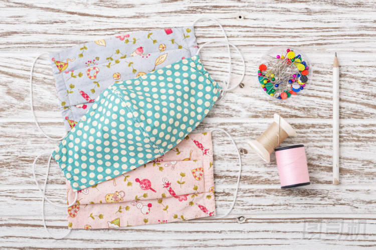 DIY織物面罩與縫紉配件在鄉(xiāng)村白色木桌上。驗(yàn)尸官的保護(hù)膜