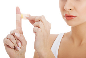 美丽的女人她的手指上把胶带