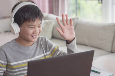十幾歲以下的男孩在家里用筆記本電腦進(jìn)行面對面的視頻通話，使用縮放在線會(huì)議應(yīng)用程序，社交距離，在家學(xué)習(xí)，在covid-19 Coronavirus期間遠(yuǎn)程學(xué)習(xí)，新的正常概念