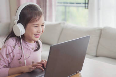 女孩在家用笔记本电脑进行面对面视频通话，使用缩放在线会议应用程序，社交疏远，在家学习，在covid-19 Coronavirus期间远程学习，新的正常概念