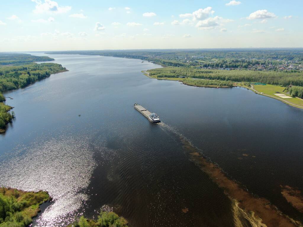 货船在空中俯瞰着被森林环绕的河流。从高处看美丽的全景