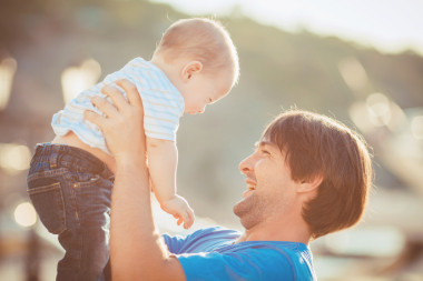 爸爸在夏天在游艇俱乐部附近的码头上和他的儿子玩。户外