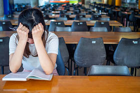独自坐在学校桌旁的女孩感到孤独，觉得太孤独