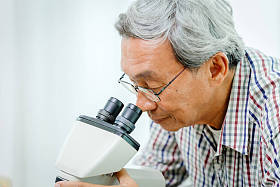 中国亚洲医生在医院实验室显微镜下观察病毒医学科学与研究