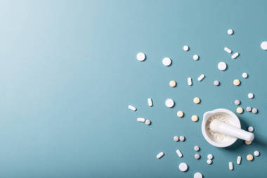 藥丸和膠囊覆蓋藍色紋理背景。頂部視圖。復制空間