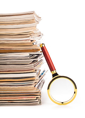 一堆报纸和放大镜图片