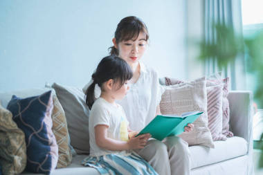 母親和女兒坐在沙發(fā)上看畫冊圖片