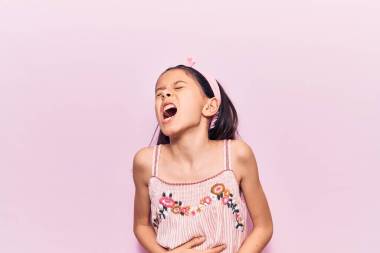漂亮的小女孩穿著休閑裝，雙手放在肚子上，因?yàn)閻盒摹⑼纯嗟募膊「杏X(jué)不舒服。疼痛的概念. 