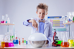 微笑的男孩进行化学实验室的实