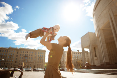 時尚現(xiàn)代的母親與一輛嬰兒車的城市街道上。年輕的米
