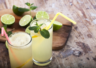 新鲜的酸橙和柠檬汽水木制背景