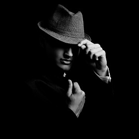 低的年轻歹徒戴着帽子在黑暗中的关键肖像