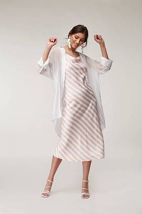 性感的时尚模特美女漂亮的脸蛋妆容，晒黑的皮肤穿夏季系列服装浪漫的约会风格走着时髦的浅色丝绸在白色粉红条纹长裙白衬衫耳环