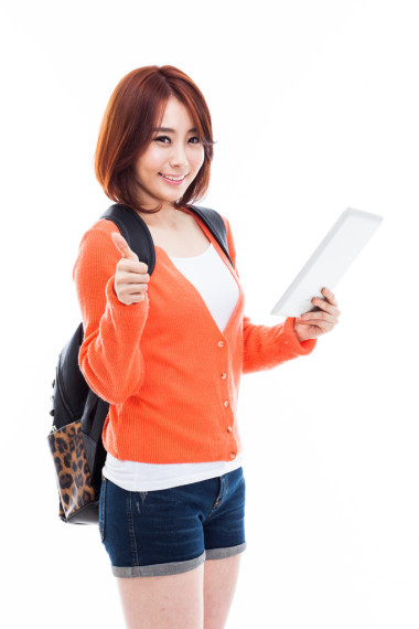 年轻的亚洲学生女人使用垫 pc