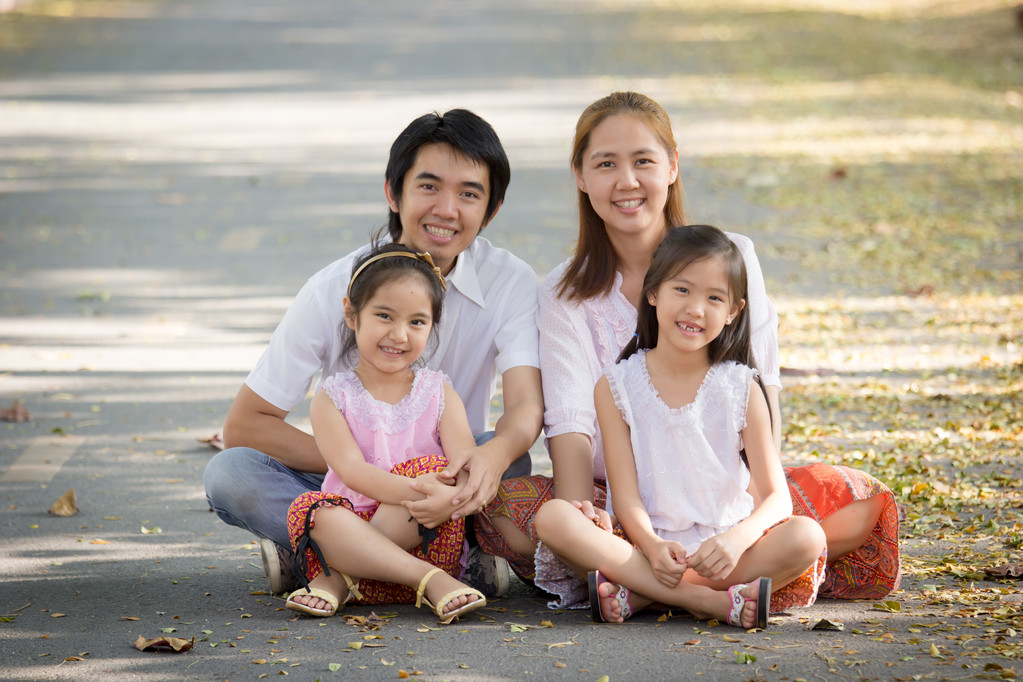 快乐亚洲家庭坐在公园