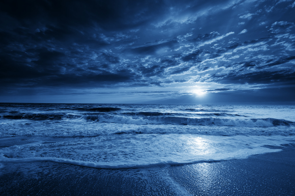 午夜蓝沿海月亮与戏剧性的天空和翻滚的波涛 午夜蓝沿海月亮与戏剧性的天空和翻滚的波涛