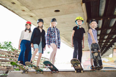 城市里的極限運(yùn)動兒童滑板俱樂部。一群朋友在滑雪場的斜坡上擺姿勢.早期的青春期在滑冰訓(xùn)練中。朋友們在街上的滑板上滑行滑板