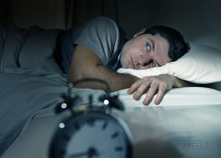 男人在床上用眼睛打開遭受失眠和睡眠障礙