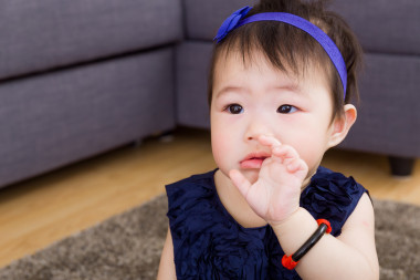 吮吸的手指與海軍藍(lán)色敷料的寶貝女兒