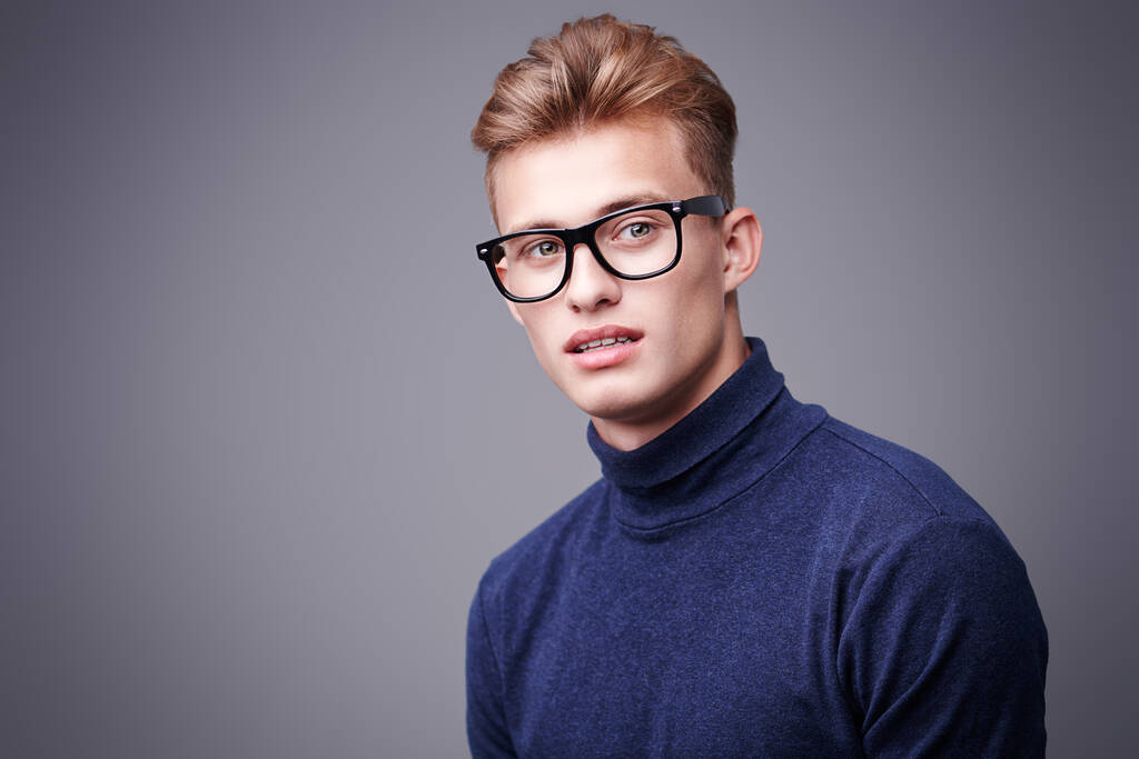男人的美丽。一个金发碧眼、头戴眼镜、朝前看的英俊年轻人的画像。男子的光学