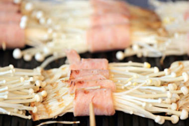 金針菇蘑菇和烤架上培根.圖片