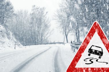 冬季驾驶-警告标志的乡间路上的降雪 冬季驾驶-警告标志的乡间路上的降雪