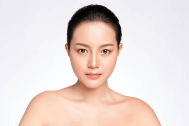 年轻美丽、面带微笑、皮肤洁白、与皮肤保健理念相分离的亚洲年轻女子的特写