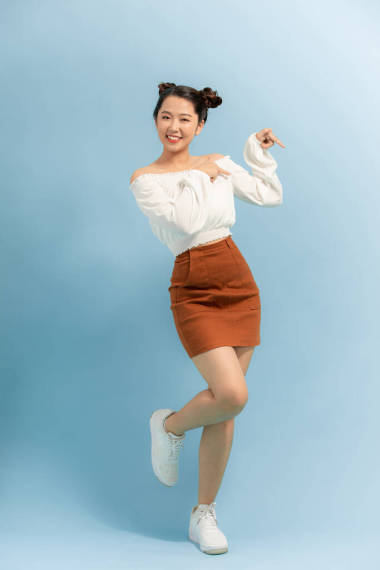 全長(zhǎng)的相貌照片可愛有趣的女士心情好漂亮的腿笑著穿上藍(lán)色背景的夏裝