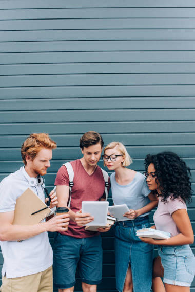 在城市街道上帶著書(shū)籍的多族裔學(xué)生 